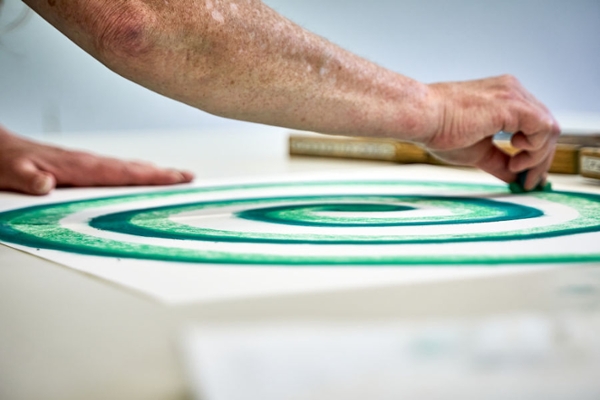 Eine Frau malt während der Kunsttherapie einen grünen Kreis